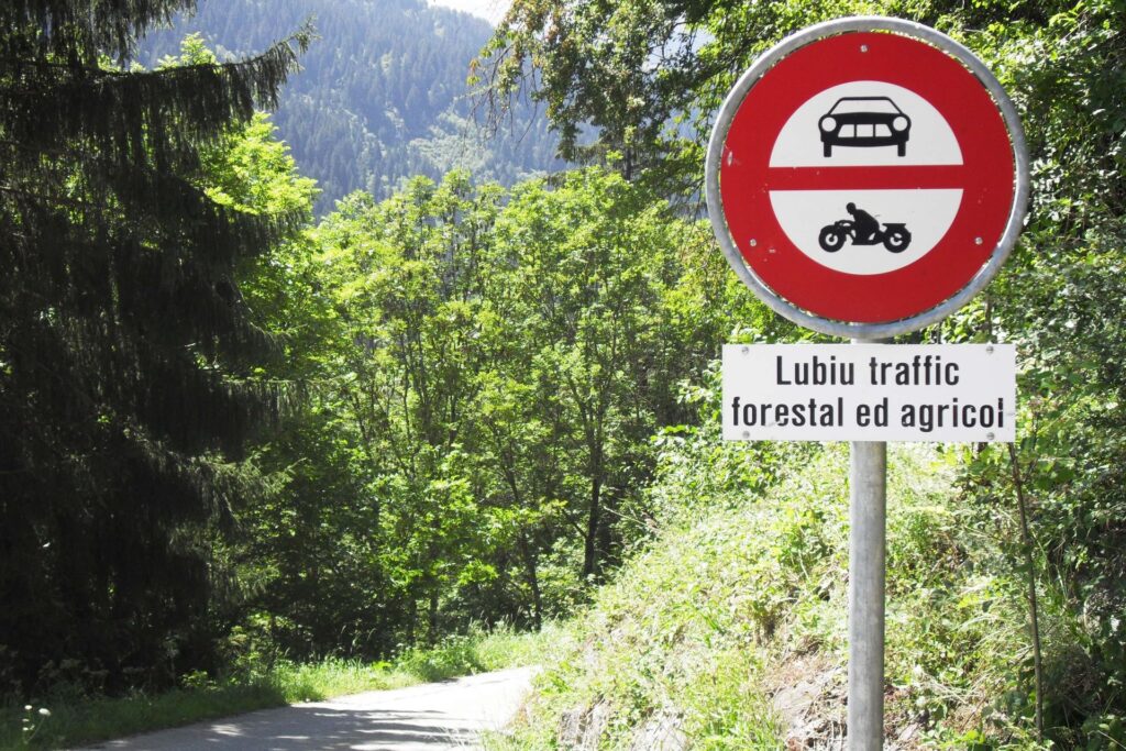 Un cartello stradale con il testo in romancio in basso