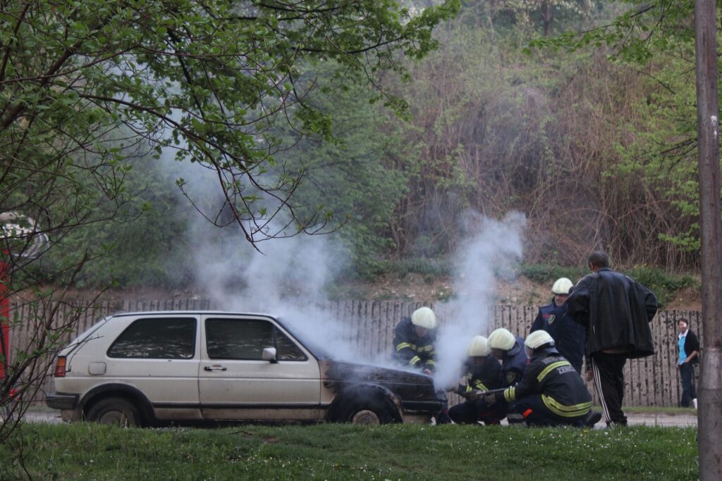 Soccorso di pompieri al ferito di un veicolo andato a fuoco