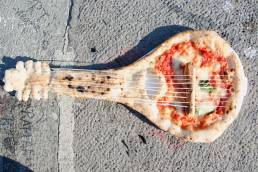 Una pizza a forma di mandolino, abbandonata a se stessa: metafora dell'italianità?