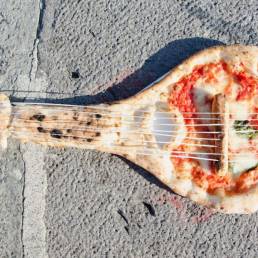 Una pizza a forma di mandolino, abbandonata a se stessa: metafora dell'italianità?