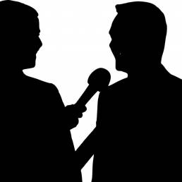 La silhouette di due persone protagoniste di un'intervista