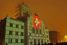 Uno spettacolo laser su Palazzo Federale a Berna: la bandiera svizzera riprodotta sulla facciata