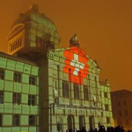 Uno spettacolo laser su Palazzo Federale a Berna: la bandiera svizzera riprodotta sulla facciata
