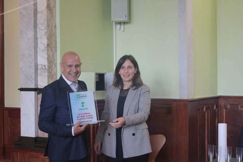 Il Dott. Raimondo Pische mentre riceve il premio dall'Avv. Anna Putrino, Vice-Presidente del Com.It.Es di Zurigo