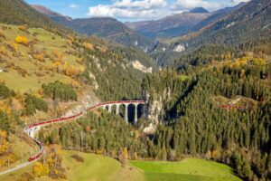 BERGUEN, 29OKT22 - Flugaufnahme vom Weltrekordversuch mit dem laengsten Reisezug auf der UNESCO Welterbestrecke der Albula-Linie am 29. Oktober 2022 auf dem Landwasserviadukt in Filisur in Graubuenden (Schweiz).  swiss-image.ch/Philipp Schmidli BERGUEN, 29OCT22 - Aerial photo of the world record attempt with the longest passenger train on the UNESCO World Heritage route 'Albula' on October 29, 2022 in Beguen in Graubuenden/Switzerland. © PHILIPP SCHMIDLI